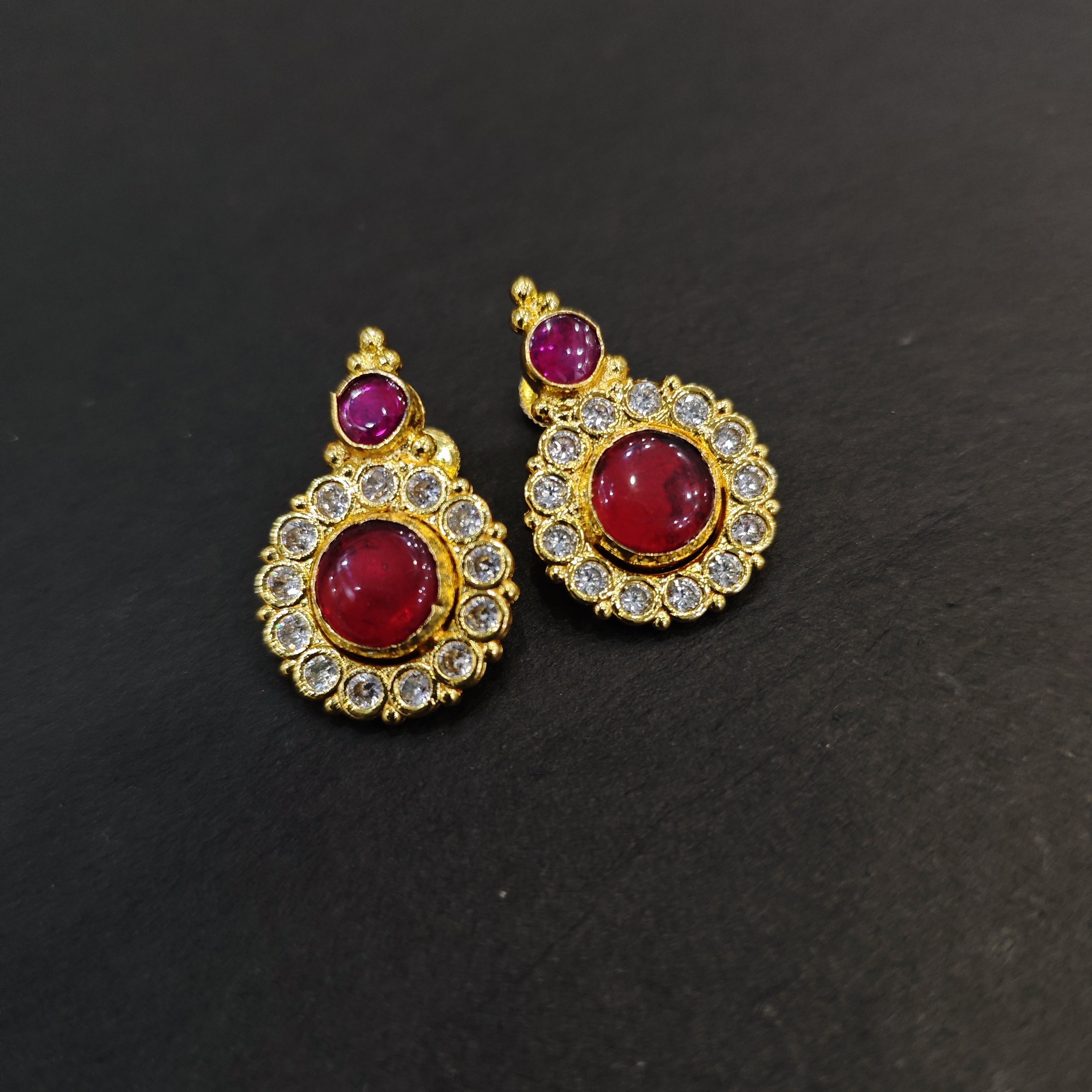 Gold plated red round palakka with white stone stud