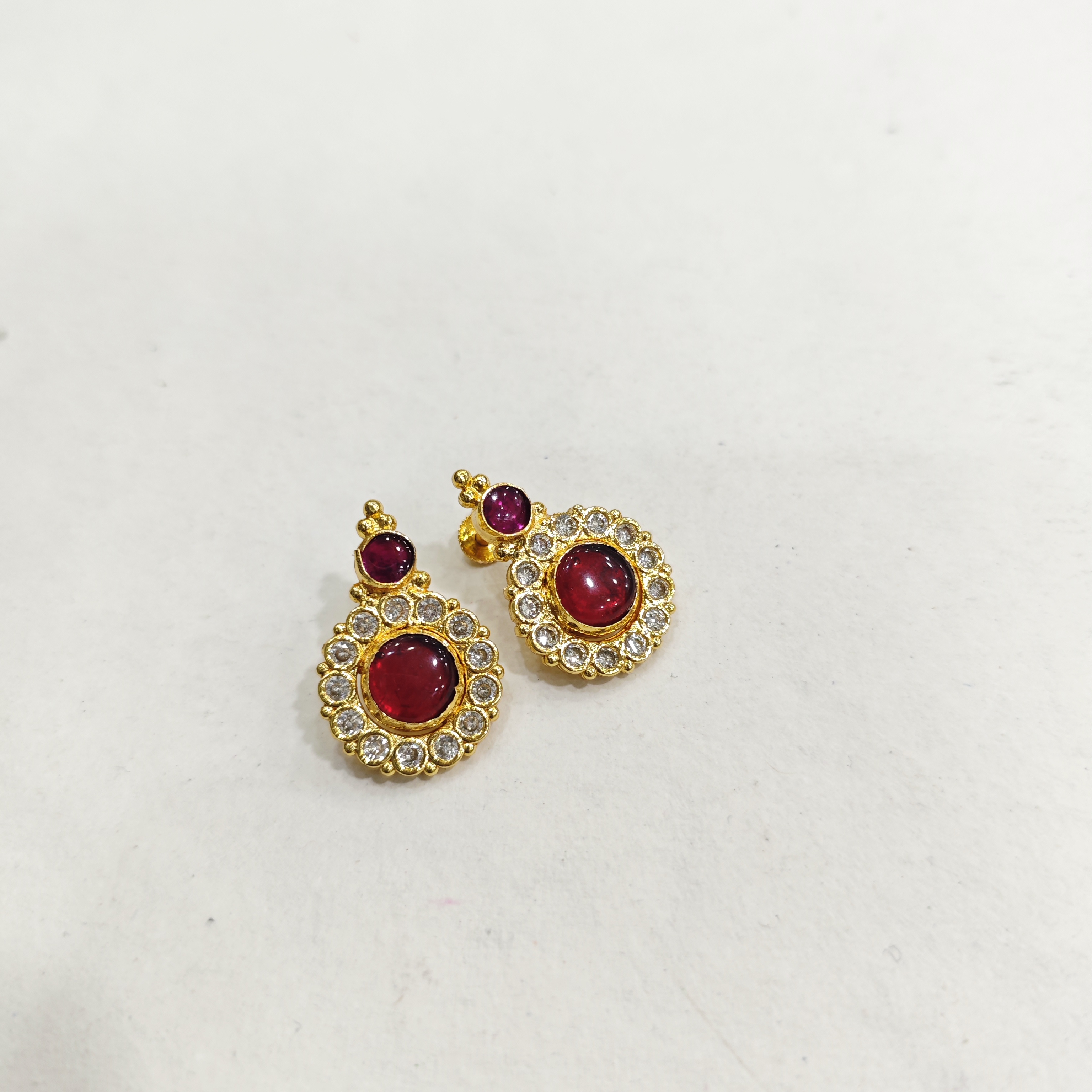 Gold plated red round palakka with white stone stud