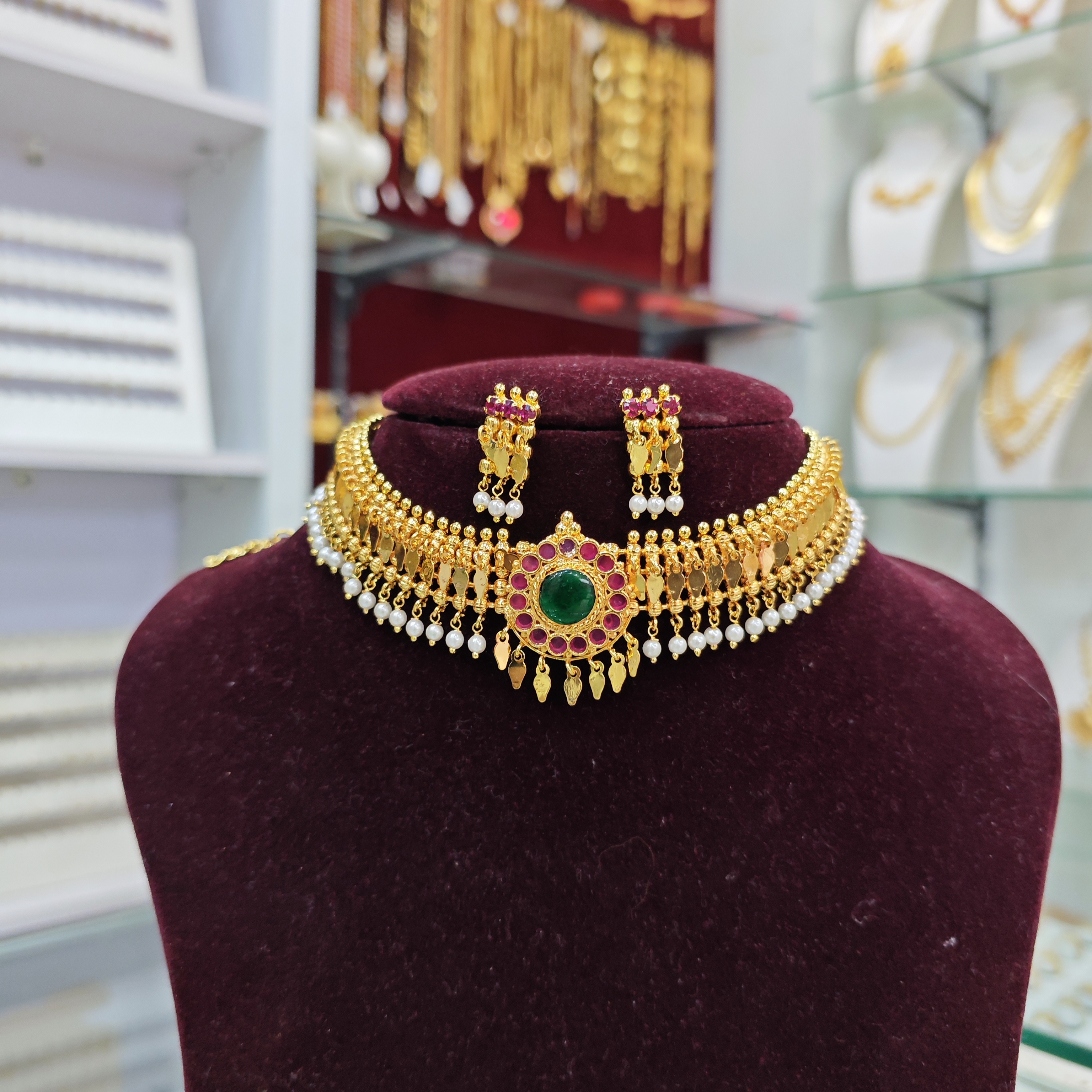 gold plated pearl elakkathali with green center locket with ruby stone elakkathali